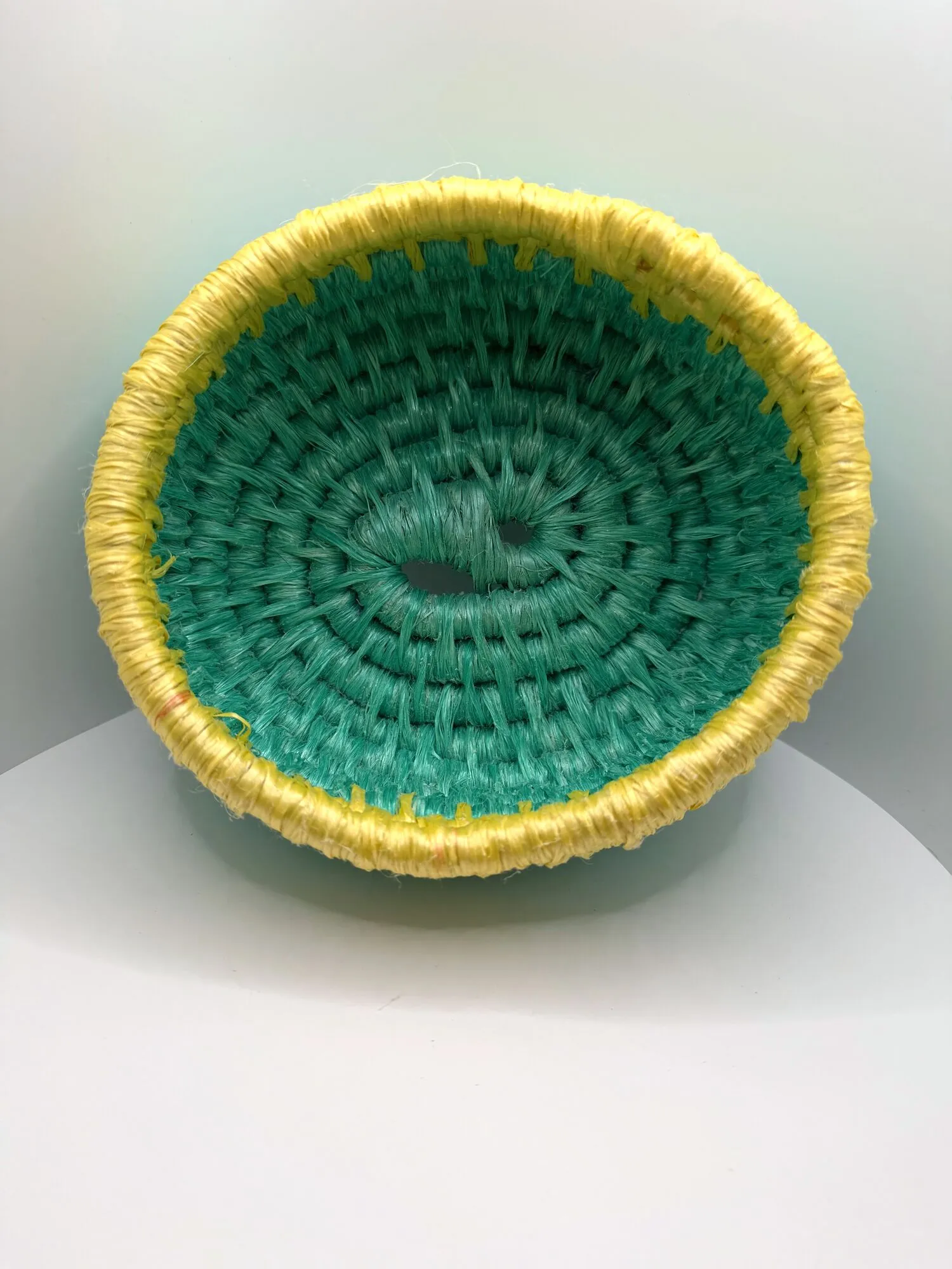 Aqua rope bowl with a yellow rim, seen from above